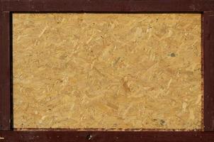 OSB boards are made of brown wood chips sanded into a wooden background photo