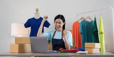 jóvenes asiáticas felices después de un nuevo pedido del cliente. cara de sorpresa y conmoción del éxito de una mujer asiática al hacer una gran venta de su tienda en línea. venta en línea. las compras en línea foto