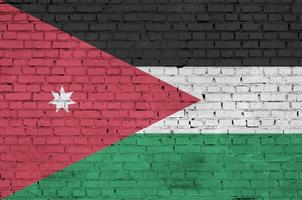 La bandera de Jordania está pintada en una pared de ladrillos antiguos. foto