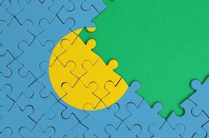 Palau flag is depicted on a completed jigsaw puzzle with free green copy space on the right side photo