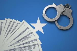 Somalia flag with handcuffs and a bundle of dollars. The concept of illegal banking operations in US currency photo