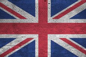 Great britain flag depicted in paint colors on old brick wall. Textured banner on big brick wall masonry background photo