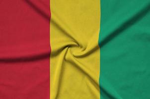 Guinea flag is depicted on a sports cloth fabric with many folds. Sport team banner photo