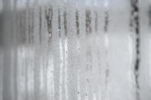 The texture of a misted glass with a lot of drops and condensation flows. Background image photo