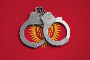 Kyrgyzstan flag and police handcuffs. The concept of observance of the law in the country and protection from crime photo