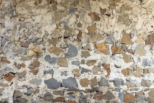 Texture of a stone wall with many big brown and grey stones armed with cement. Old castle stone wall texture background for medieval usage. Part of a stony building photo