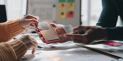 UI UX creative designer team designing wireframe layout for responsive mobile smartphone application in office photo