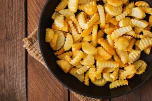 Frying pan with a fried potato in a rural way on a wooden background. photo