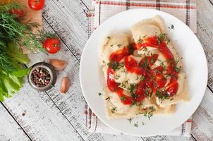 Delicious ravioli with tomato sauce and dill photo