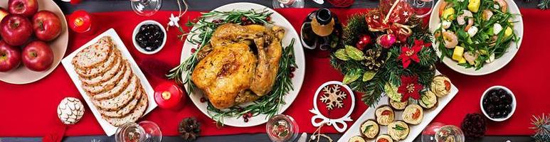 pavo al horno. cena de Navidad. la mesa navideña se sirve con un pavo, decorado con oropel brillante y velas. pollo frito, mesa. cena familiar. vista superior