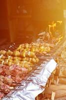 Raw meat and potatoes are planted on metal skewers. The process of cooking shish kebabs. Russian and Ukrainian camp food photo