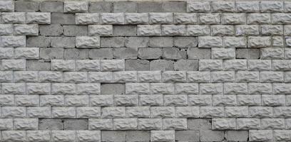 Grey concrete block wall texture with cracked surface photo
