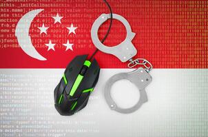 Singapore flag and handcuffed computer mouse. Combating computer crime, hackers and piracy photo