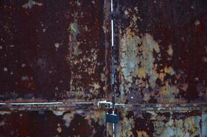 Rusty metal gate with lock photo