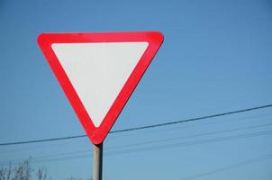 Traffic sign in the form of a white triangle. Give way photo