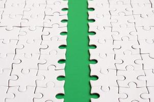 The green path is laid on the platform of a white folded jigsaw puzzle. Texture image with copy space for text photo