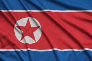 la bandera de corea del norte está representada en una tela deportiva con muchos pliegues. bandera del equipo deportivo foto