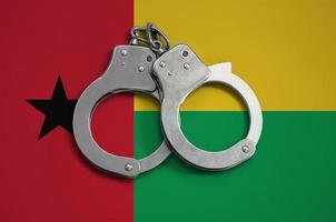 Guinea Bissau flag and police handcuffs. The concept of observance of the law in the country and protection from crime photo