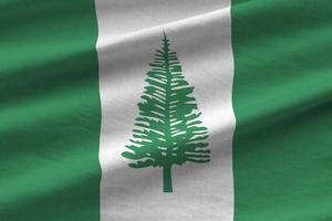 Norfolk island flag with big folds waving close up under the studio light indoors. The official symbols and colors in banner photo