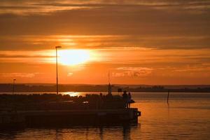 Sunset in Sweden at the harbor of lake Vaettern. Lighthouse in the background photo