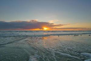 Sunset on the beach in Denmark. Waves rolling over the sand. Walk on the coast photo