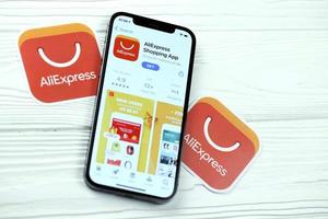 KHARKOV, UKRAINE - MARCH 5, 2021 Aliexpress icon and application from App store on iPhone 12 pro display screen on white table photo