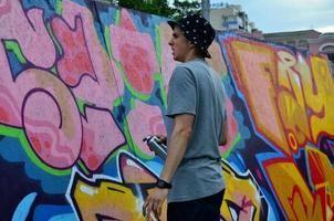 KHARKOV, UKRAINE - MAY 27, 2017 Festival of street arts. Young guys draw graffiti on portable wooden walls in the center of the city. The process of painting on walls with aerosol spray cans photo