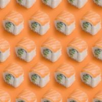 Philadelphia rolls with salmon on orange background. Minimalism top view flat lay pattern with Japanese food photo