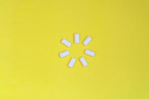 A few chewing gums lie on texture background of fashion pastel yellow color paper in minimal concept photo