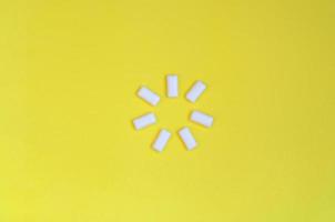 A few chewing gums lie on texture background of fashion pastel yellow color paper in minimal concept photo