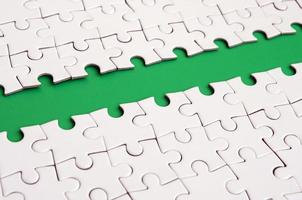 The green path is laid on the platform of a white folded jigsaw puzzle. Texture image with copy space for text photo