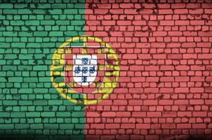 Portugal flag is painted onto an old brick wall photo