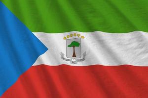 Equatorial Guinea flag with big folds waving close up under the studio light indoors. The official symbols and colors in banner photo