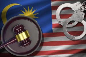 Malaysia flag with judge mallet and handcuffs in dark room. Concept of criminal and punishment, background for judgement topics photo