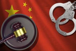 China flag with judge mallet and handcuffs in dark room. Concept of criminal and punishment, background for judgement topics photo