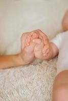 Mother holding her newborn baby by little hand, baby feels love and security from mother photo