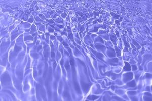 Defocus blurred transparent purple colored clear calm water surface texture with splash, bubble. Shining purple water ripple background. Surface of water in swimming pool. Purple bubble water shine. photo