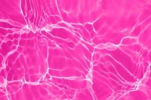 desenfoque borrosa transparente de color púrpura claro agua tranquila textura de la superficie con salpicaduras, burbujas. fondo de ondulación de agua púrpura brillante. superficie del agua en la piscina. brillo de agua de burbuja púrpura. foto