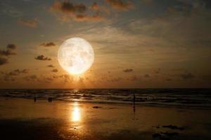 Landscape moon over the horizon on sea and moonlight. Panorama with the luna of night. Grand mystical fantastic view. Mid-Autumn Festival or Halloween concept. The full moon on the beach. photo