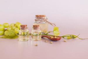 a set of different glass bottles with cork cap with natural organic grape seed oil. elixir of youth. pastel background. photo