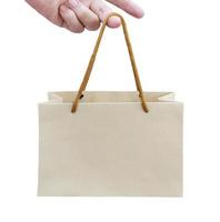 fingers holding recycled paper bags on white background photo