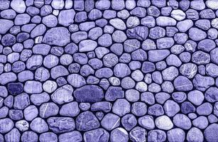 purple violet background of rounded stones, pebbles, copy space in trendy Colors of the year 2022 very peri photo