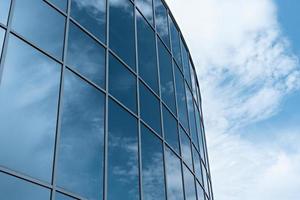 reflejo del cielo nublado en un edificio moderno con grandes espejos foto