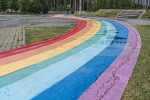 arco iris sinuoso camino húmedo con charcos después de la lluvia, espacio de copia, fondo colorido foto