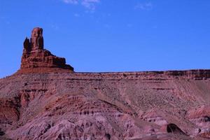 Lone Rock Formation Jutting Above Desert Plateau photo