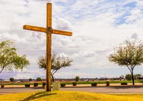 cruz de madera en el montículo contra el cielo nublado foto