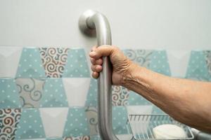 Asian senior or elderly old lady woman patient use toilet bathroom handle security in nursing hospital ward, healthy strong medical concept. photo