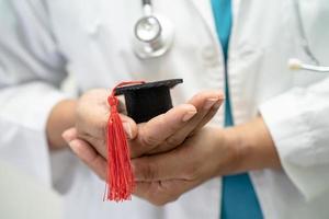 el estudio de un médico asiático aprende con un sombrero de brecha de graduación en la sala del hospital, un concepto de medicina inteligente y brillante. foto