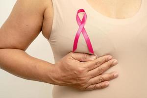 cáncer de mama, cinta rosa a la anciana asiática por apoyar la conciencia, símbolo del día mundial del cáncer de mama. foto