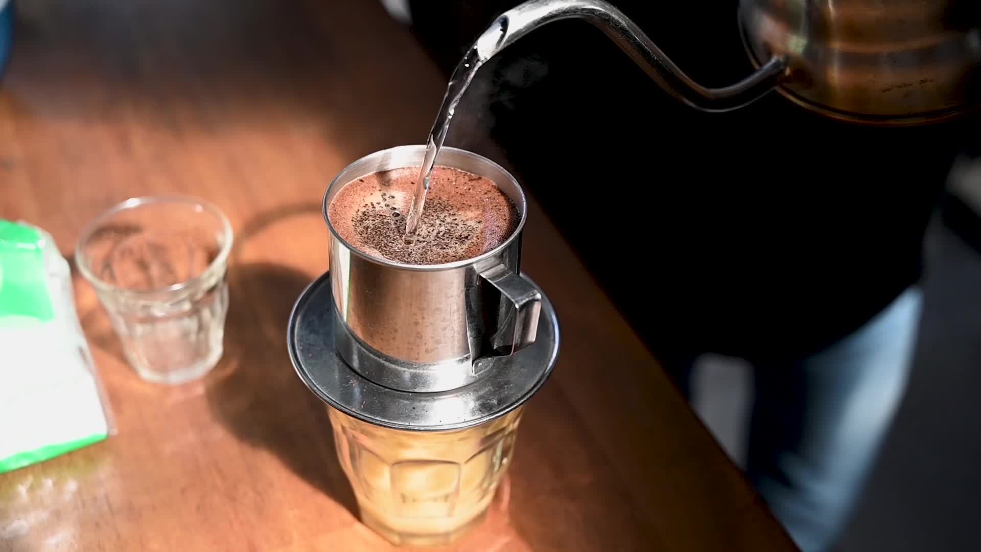 the process of serving Vietnamese drip coffee, from filtering drips to